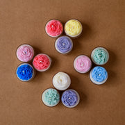 Colorful flower-shaped candles arranged on a brown background